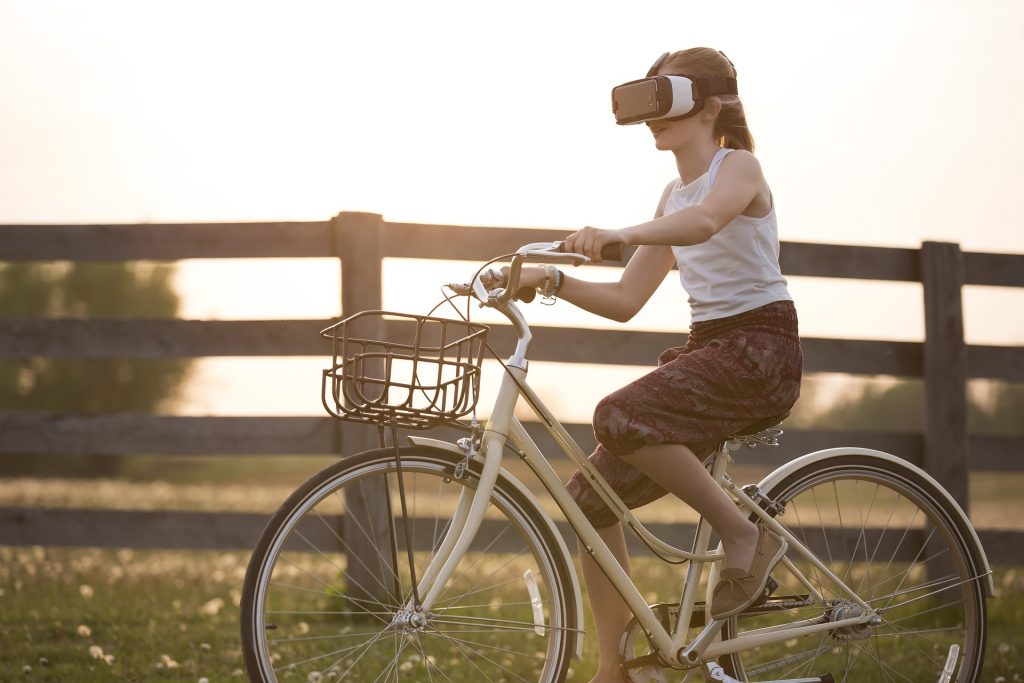 VRゴーグルをかけて自転車に乗る女性
